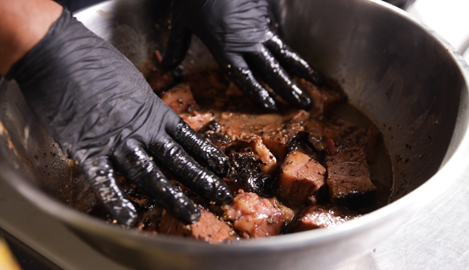 Burnt Ends Being Tossed in Crossbuck BBQ's Sweet Saucy Mixture