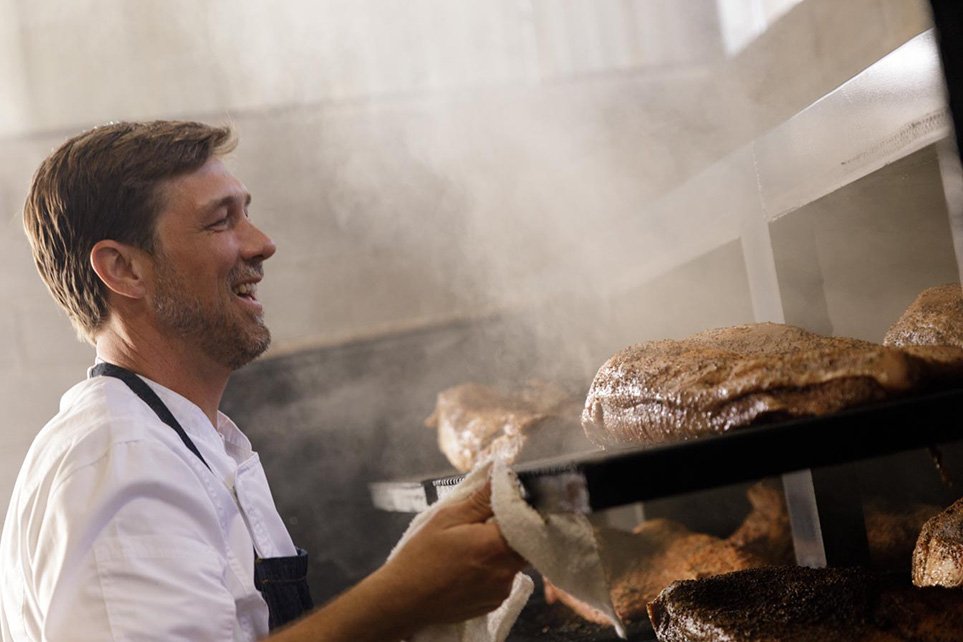 Pitmaster Tim McLaughlin Pulling A Brisket out of Smoker