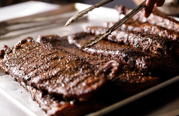 Dallas Style BBQ Ribs being prepared for nearby catering order