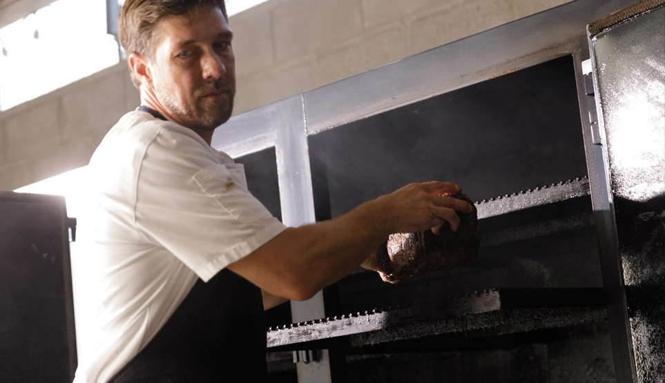 Famed Pitmaster Tim McLaughlin pulling a smoked prime rib from smoker