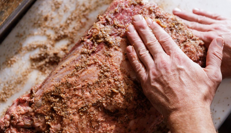 Crossbuck BBQ's prime rib being seasoned with bacon fat and other seasonings